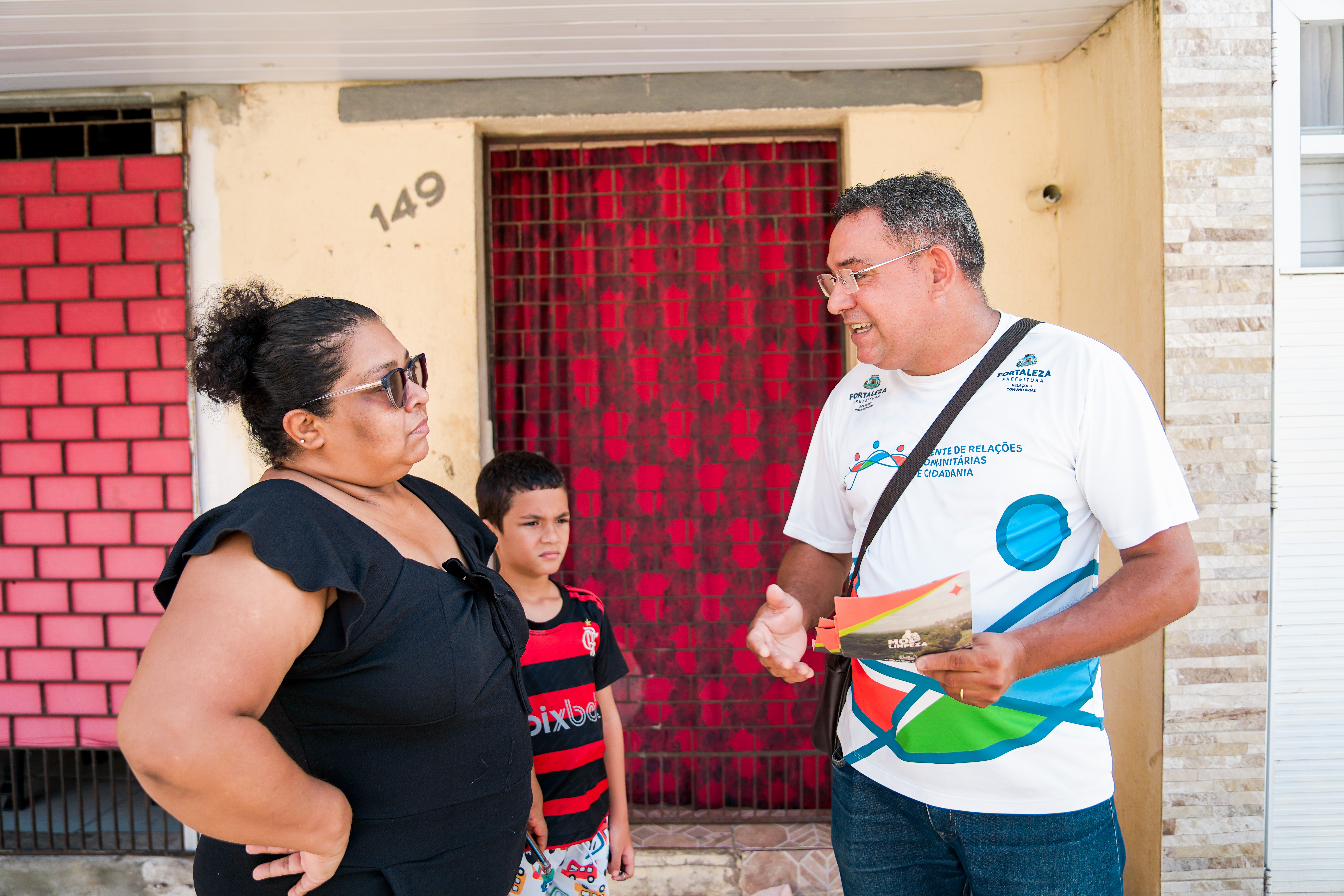 homem entrega folheto para uma senhora